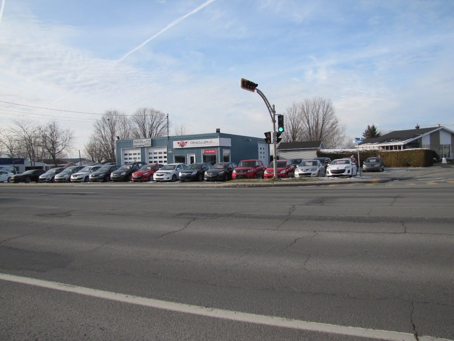 La cour et l'enseigne des Véhicules JC vues du coin de rue à Princeville